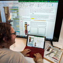 A lady enters information into a computer. The monitor shows a chimney and copy.
